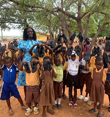 Some students showing their new shoes they received from the Growth Mindset Development Foundation